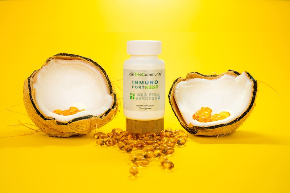 CBD capsules with coconut shells on a vibrant yellow background.