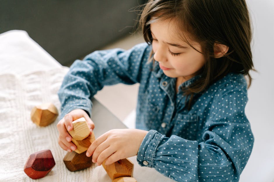 A girl enjoying a mindful and sustainable activity with wooden blocks indoors.