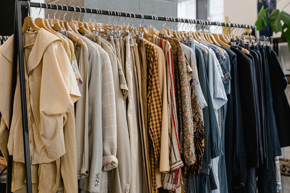 A diverse selection of garments hanging on a clothes rack in a modern fashion boutique.