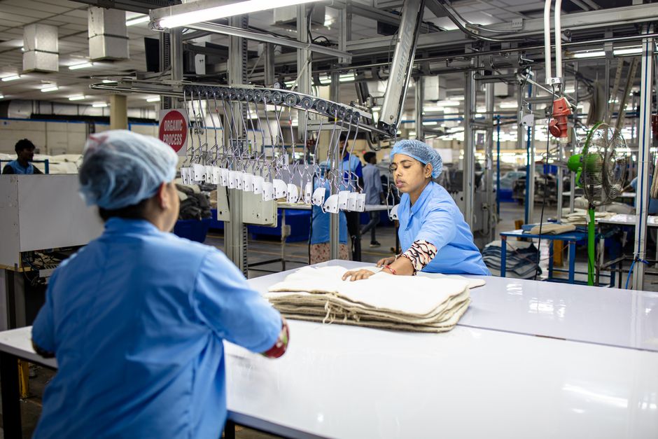 Two workers in a textile factory managing the production line for efficient fabric processing.