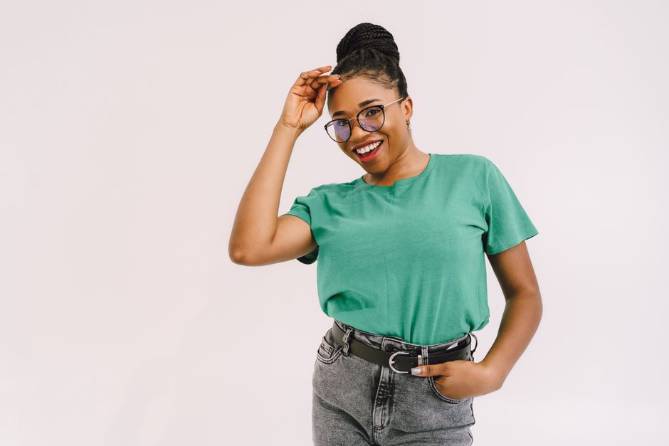 Confident woman smiling in green t-shirt and jeans, perfect for lifestyle and fashion themes.