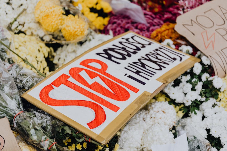 Protest signs amidst flowers in Poland raising social awareness.