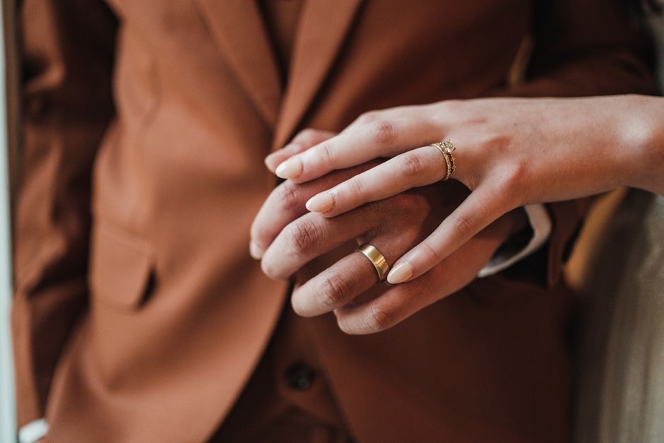 Intimate close-up of a couple's hands adorned with wedding rings, symbolizing love and commitment.