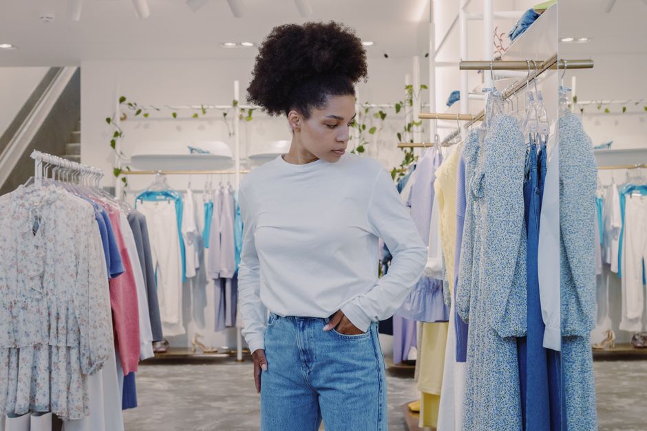 Woman browsing stylish clothes in a modern boutique, dressed casually.