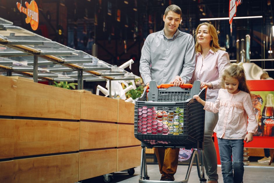 A cheerful family with a child shopping indoors at a supermarket, enjoying quality time together.